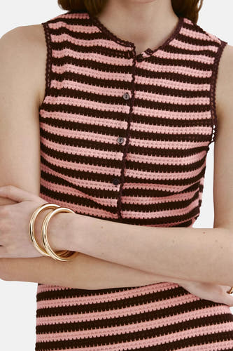 Multicolor gestreepte korte gilet van MANGO, gehaakt met knoopsluiting en ruches aan de zoom, gedragen met gouden armbanden.