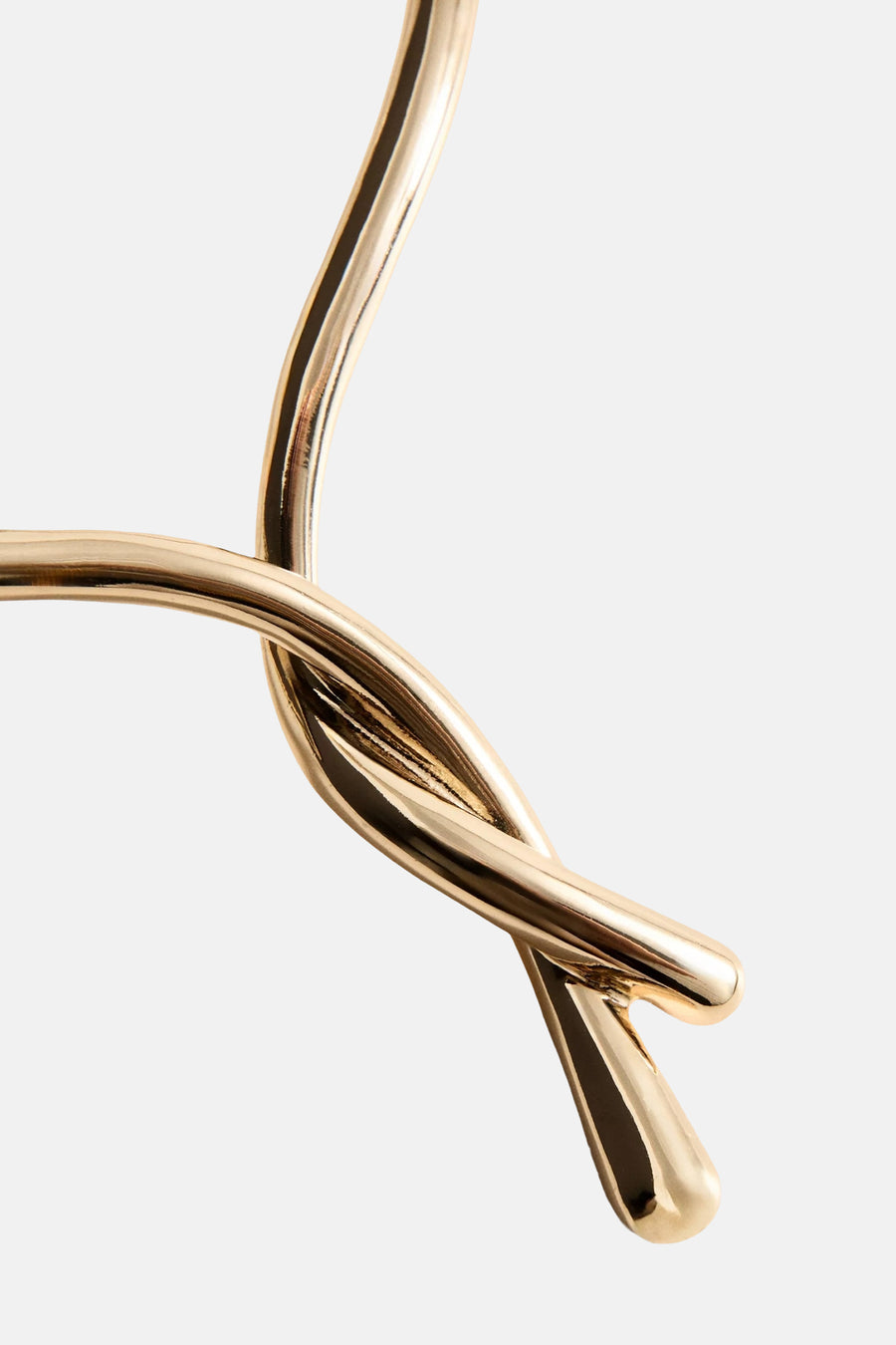 Gouden korte halsketting met gevlochten detail van MANGO, close-up op de glanzende knoopstructuur