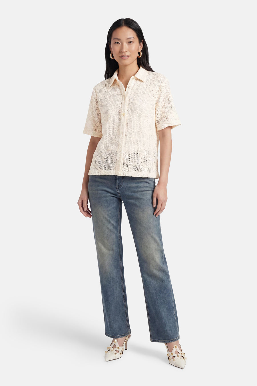 Chemisier beige à manches courtes de Terra di Siena, avec motif ajouré, porté avec un jean et des escarpins.