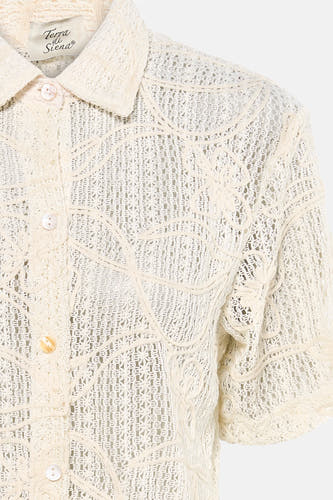 Chemisier beige à manches courtes de Terra di Siena, avec motif floral ajouré au crochet et fermeture à boutons.