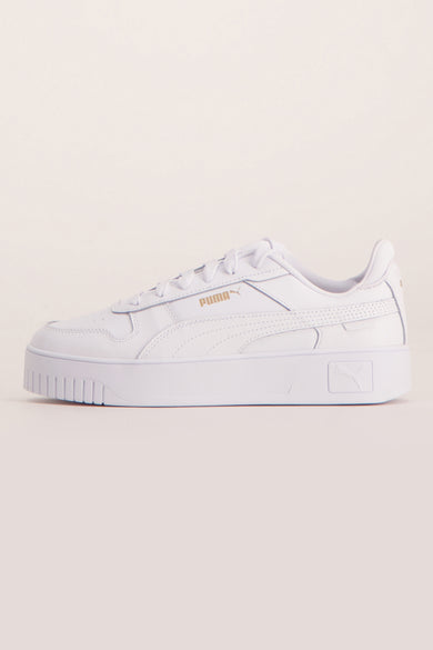 Sneakers blanches de PUMA, avec une semelle blanche épaisse et un nom de marque doré.