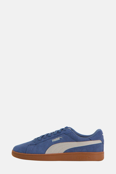 Sneakers bleues de PUMA, avec une bande blanche et une semelle brune.