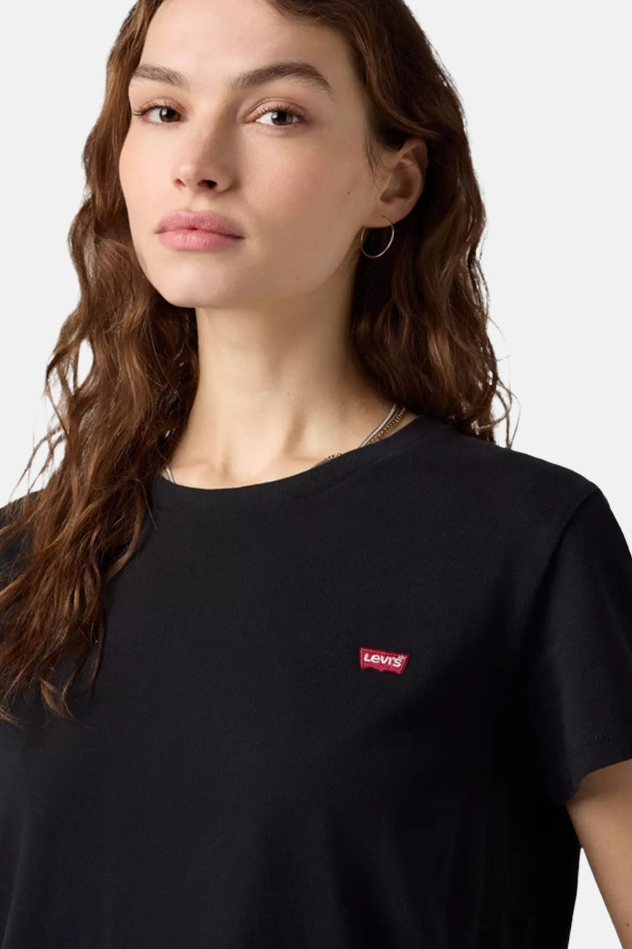 Zwart korte mouwen T-shirt van Levi's® met klein rood logo op borst, gedragen door model met krullend haar, close-up voorzijde