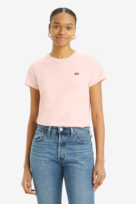 Vrouw draagt roze Levi's T-shirt en blauwe spijkerbroek.