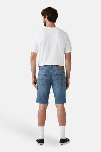 Short de denim bleu marine de Levi's, avec des poches arrière et une étiquette de marque rouge, associé à un T-shirt blanc, des chaussettes blanches et des chaussures noires.