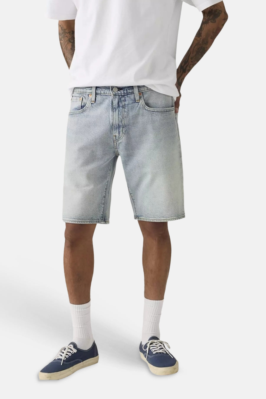 Lichtblauwe denim shorts van Levi's® met gewassen look, klassieke vijfzakkenstijl, gedragen met wit T-shirt en blauwe sneakers.