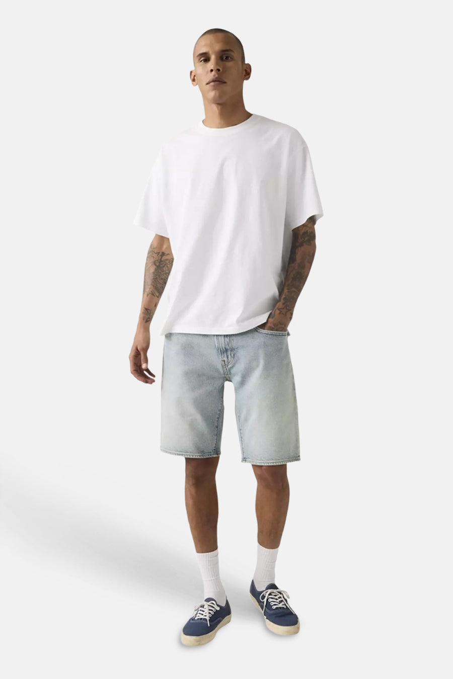 Lichtblauwe denim shorts van Levi's® met gewassen look, gedragen met wit T-shirt en blauwe sneakers, front view.