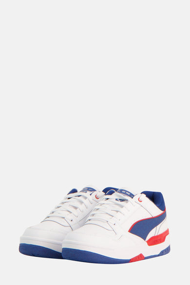 Sneakers multicolores de PUMA, avec des lacets blancs et des détails en bleu et rouge.