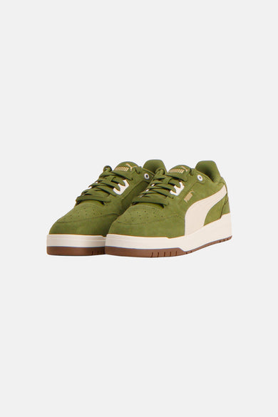 Baskets vertes PUMA, avec des accents crème et le logo PUMA sur le talon, vues de dos.