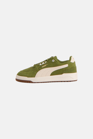 Baskets vertes PUMA, avec une bande crème et une semelle marron.