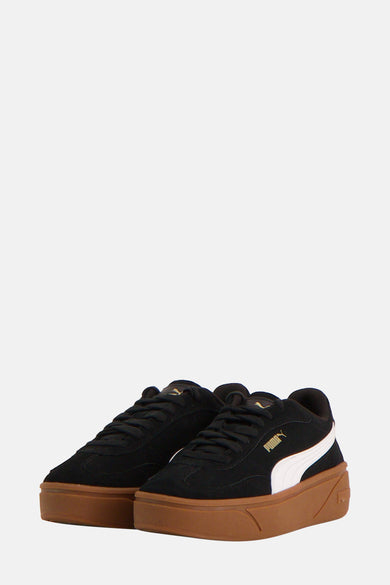 Sneakers noirs de PUMA, avec des rayures blanches et une semelle brune, vus par derrière.