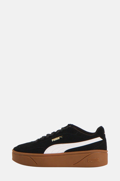 Sneakers noirs de PUMA, avec une bande blanche et une semelle brune.
