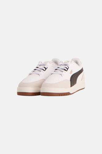 Baskets blanches PUMA, avec des accents marron et le logo à l'arrière.