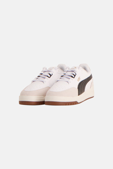 Baskets blanches PUMA, avec des accents marron et le logo à l'arrière.