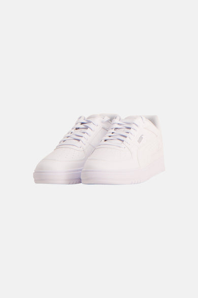 Sneakers blanches de PUMA, vues de derrière avec un logo argenté.