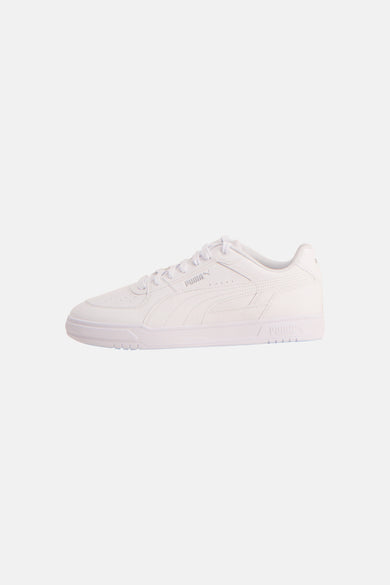 Sneakers blanches de PUMA, en vue latérale et avec des lacets.