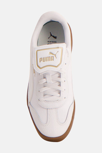 Witte sneakers van PUMA met gouden logo op de tong en een bruine zool.
