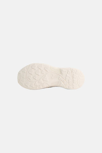 Grijze sneakers van PUMA, onderaanzicht van lichtbeige zool met driehoekig noppenpatroon en PUMA-logo in reliëf.