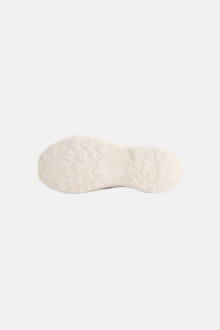 Grijze sneakers van PUMA, onderaanzicht van lichtbeige zool met driehoekig noppenpatroon en PUMA-logo in reliëf.