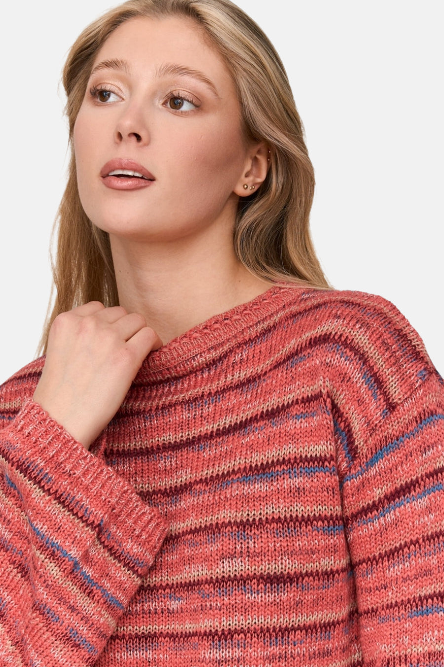 Vrouw met blond haar, roze gestreepte gebreide trui.
