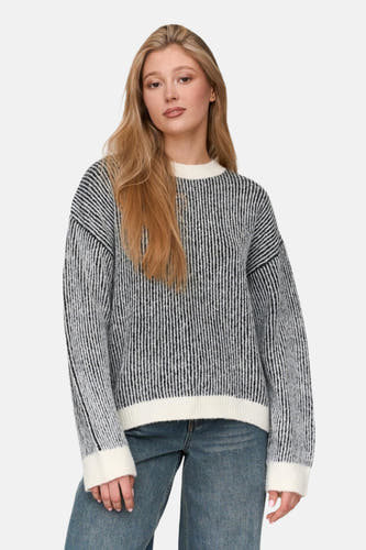 Pull-over noir à col rond de 24 Colleurs, avec un un un motif rayé, combiné avec des jeans.