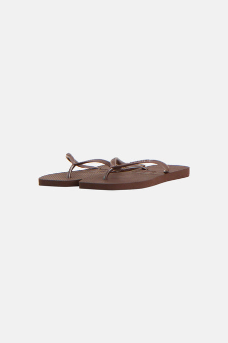 Une paire de tongs marron Havaianas, avec des fines brides et une semelle texturée.