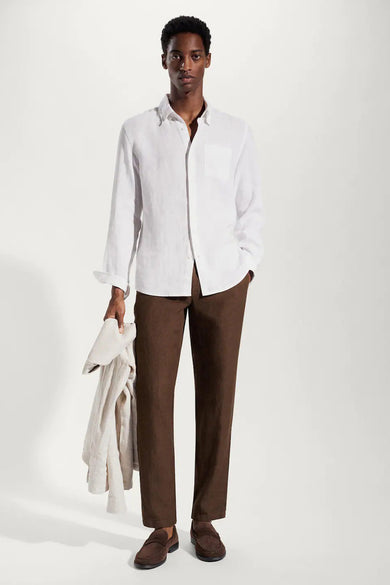 Pantalon costum de couleur marron de MANGO, porté avec une chemise blanche en lin et des loafers en cuir de Suède.