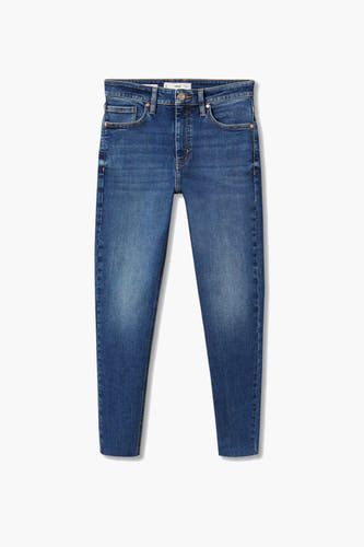 Jean skinny bleu denim de MANGO avec délavage léger, rivets en bronze et ourlets effilochés.