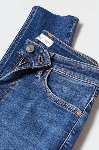 Jean skinny bleu moyen de MANGO, avec surpiqûres orange, braguette zippée et fermeture à bouton.