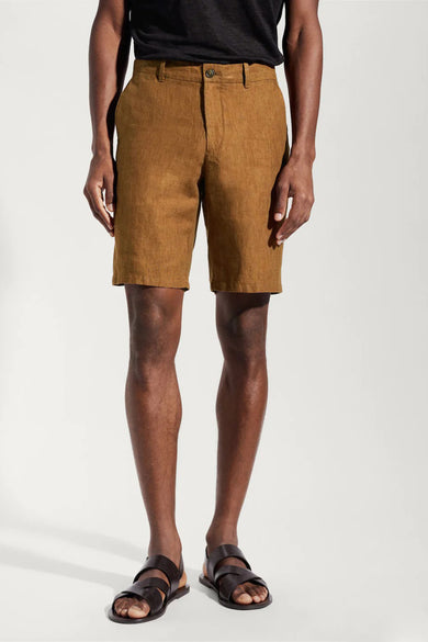 Short marron de MANGO, associé à un t-shirt noir et des sandales en cuir marron foncé.