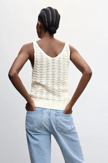 Débardeur beige en maille avec motif ajouré de MANGO, vue arrière portée par un mannequin en jean bleu clair
