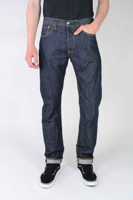 Jean droit bleu foncé de Levi's, avec une étiquette rouge de la marque sur la poche arrière et une étiquette en cuir marron sur la ceinture.