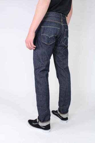 Jean droit bleu foncé de Levi's, avec coutures apparentes et jambes retroussées, vu de dos.