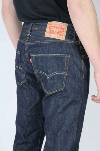 Jean droit bleu foncé de Levi's, avec étiquette rouge visible sur la poche arrière et patch en cuir sur la ceinture.
