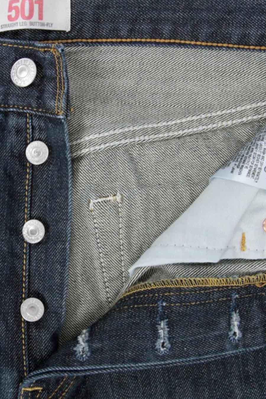 Jean droit bleu foncé de Levi's, avec fermeture à boutons et surpiqûres caractéristiques, gros plan recadré.