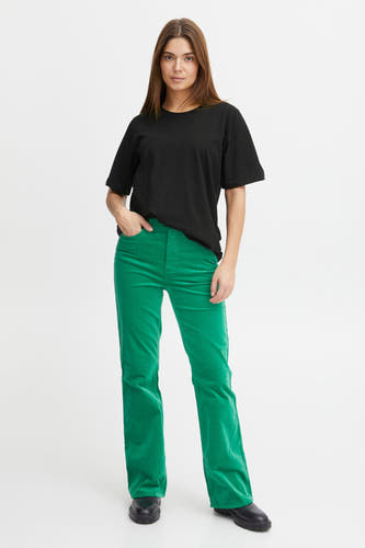 Zwart T-shirt met korte mouwen van PULZ, met een losse pasvorm, gecombineerd met een groene corduroy broek en zwarte schoenen.

