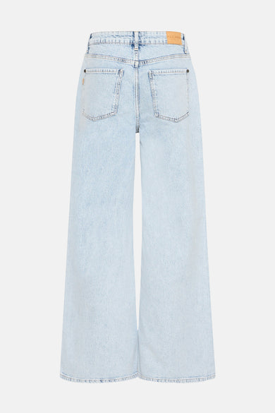 Jean en denim bleu clair large de PULZ JEANS, avec des poches arrière et une étiquette en cuir.