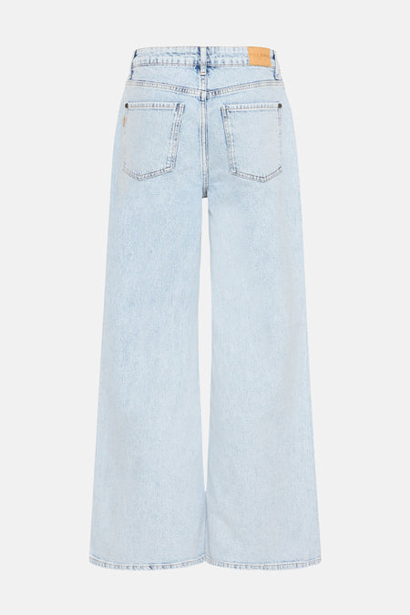 Jean en denim bleu clair large de PULZ JEANS, avec des poches arrière et une étiquette en cuir.
