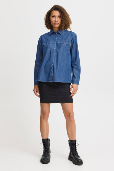 T-shirt en jeans en denim bleu moyen de PULZ, porté avec une jupe noire et des bottes noires.