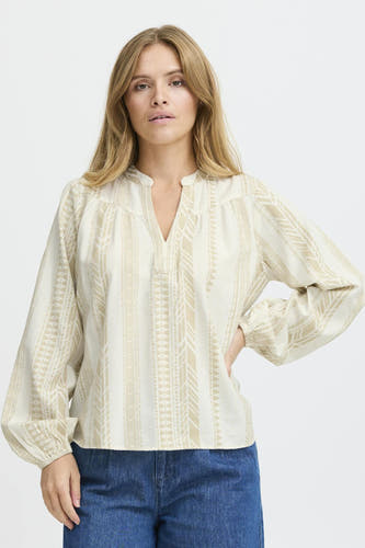 Blouse écru à longues manches de PULZ, avec un motif inspiré par l'ethnie et des jeans bleus.