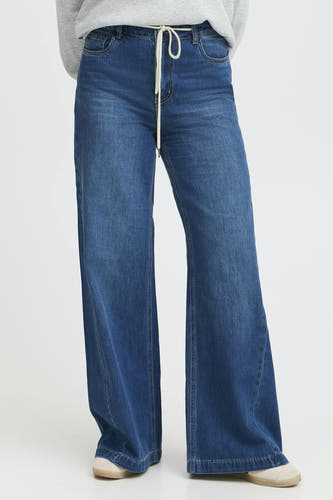 Jean décontracté de denim bleu foncé P PULZ, avec une fermeture à glissière blanche et des jambes larges.