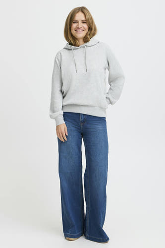 Jean délavé bleu marine de PULZ, avec des longues jambes, associé à une hoodie grise.