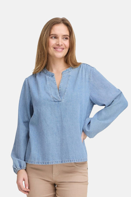 Blouse de PULZ, en un look denim bleu clair avec des manches bouffantes et une encolure ouverte.