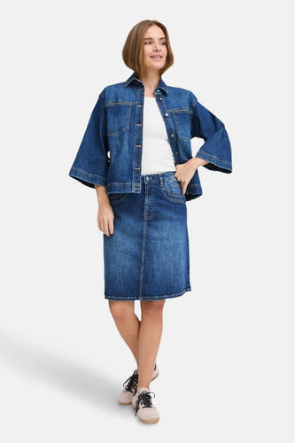 Veste de jeans bleue marine de PULZ, portée sur un chemisier blanc et une jupe en jeans.