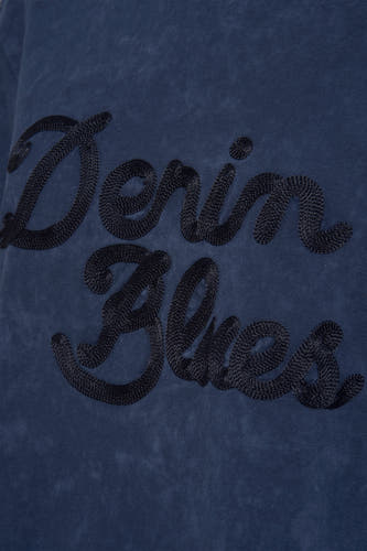 T-shirt bleu à manches courtes de PULZ, avec le texte "Denim Blues" brodé.