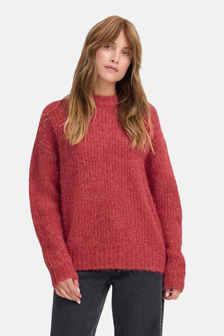 T-shirt rouge à col rond de PULZ, avec une texture tricotée épaisse et des manches longues, porté avec un jean noir.