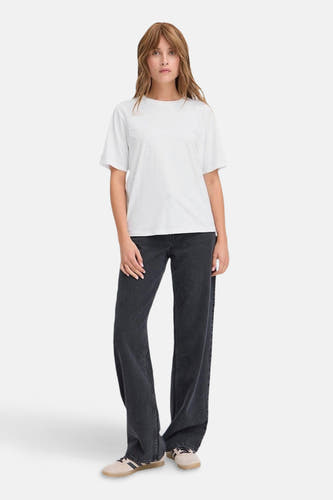 Wit T-shirt van PULZ, met subtiele versiering, gecombineerd met wijde, donkere jeans en sneakers.
