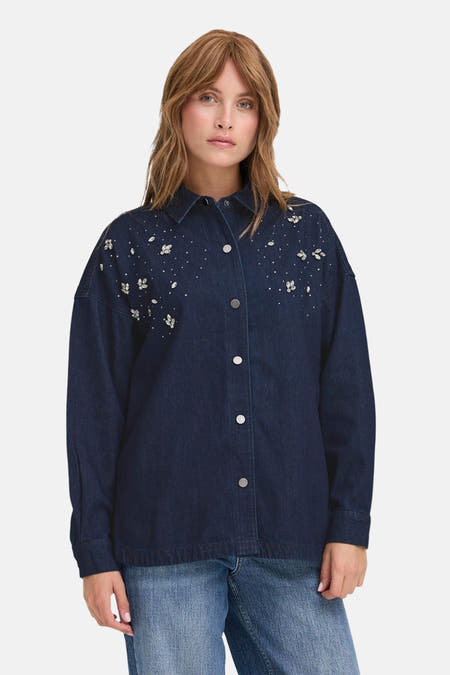 T-shirt en jeans de denim bleu marine PULZ, avec des applications strass et des manches longues, associé à un pantalon en jeans.