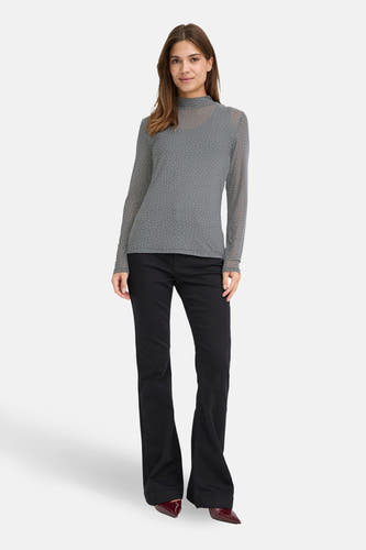 Grijs shirt van PULZ met lange mouwen en witte stippen, gedragen met zwarte broek en rode pumps.