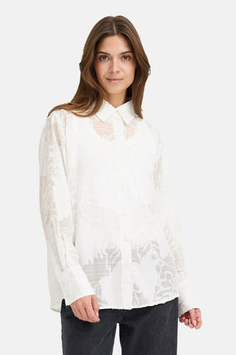 Blouse blanche à longues manches de PULZ, avec un motif floral subtil et une fermeture à boutons.
